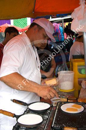 A man cooking tapioca into a kind of pancake in Manaus, Brazil.