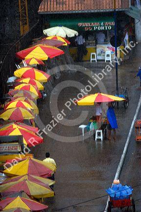 Street vendors with umbrellas in the pouring rain at Manaus, Brazil.
