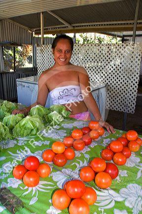 Tahitian woman selling tomatoes at a roadside stand on the island of Tahiti. MR