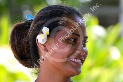 Tahitian woman wearing a plumeria flower in her hair on the island of Moorea.