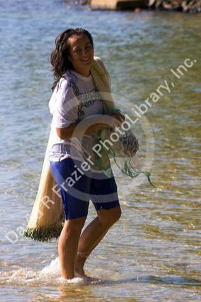 Tahitian woman net fishing on the island of Moorea.