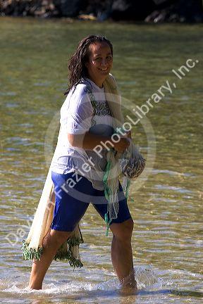 Tahitian woman net fishing on the island of Moorea.