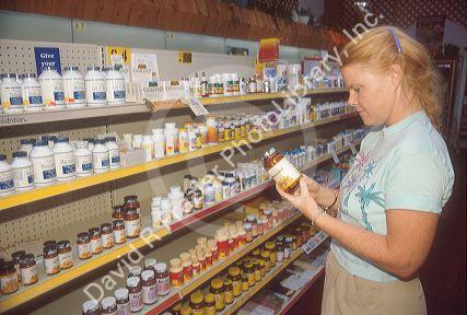 Woman shopping for vitamins at a health food store.