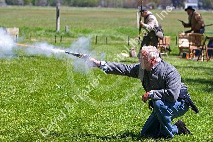Man dressed as a Confederate soldier shooting a gun during a civil war reenactment near Boise, Idaho.