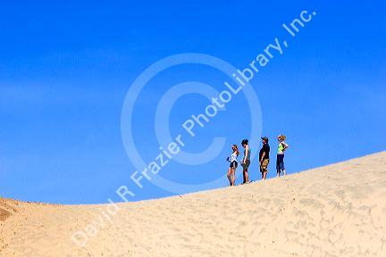 People stand on sand dunes at Pacific City on the Oregon Coast.