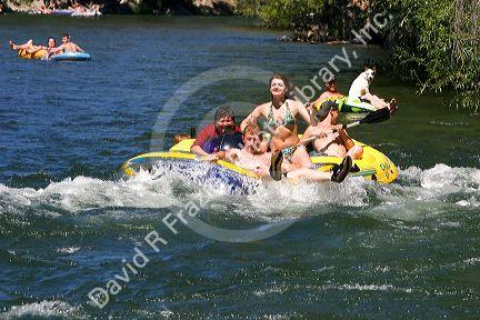People on inflatable rafts floating the Boise River in Boise, Idaho.