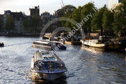 Canal boats on the Amstel River in Amsterdam, Netherlands.