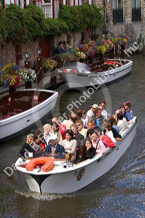 Tourists ride in a canal boat at the city of Bruges in the province of West Flanders, Belgium.