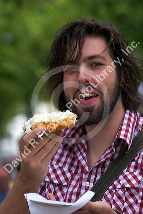 Tourist eats a belgian waffle at Bruge in the province of West Flanders, Belgium.