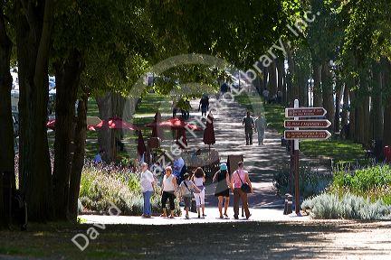 People walk on tree lined pathways at Versailles in the department of Yvelines, France.