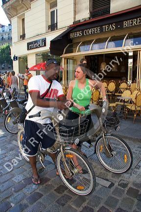 People ride rental bicycles that are part of the Velib bike transit system in Paris, France.