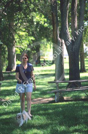 Woman walking her dog in a park.