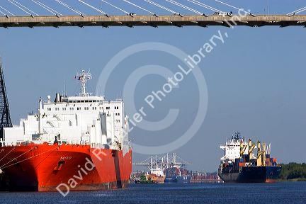 Container ships pass under the Talmadge Memorial Bridge on the Savannah River at the Port of Savannah in Savannah, Georgia.