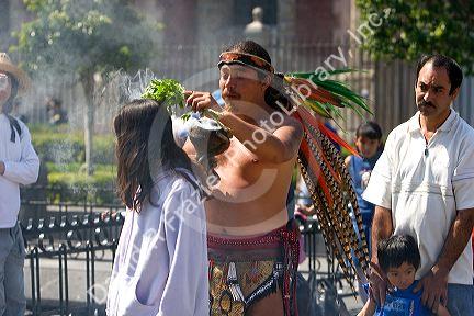 Aztec indian in traditional dress performing a spiritual ceremony using smoke on the Day of the Dead in Mexico City, Mexico.