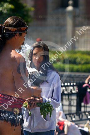 Aztec indian in traditional dress performing a spiritual ceremony using smoke on the Day of the Dead in Mexico City, Mexico.