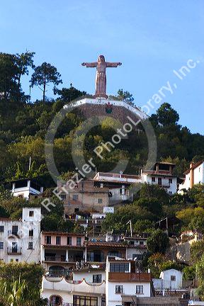 A Christ statue sits above homes built on the hillside at Taxco in the State of Guerrero, Mexico.