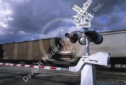A train traveling in front of a railroad crossing sign.