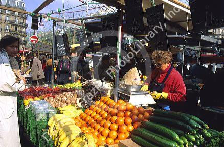 French woman shopping for fruits and vegetables at a stand in Paris, France.