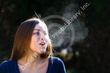 Young woman exhaling in the cold winter air. MR