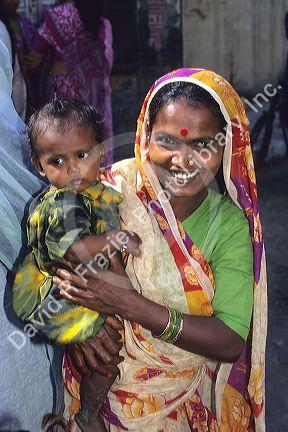 Indian woman holding a baby in New Delhi, India. Awaiting free milk delivery.