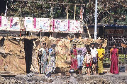 A family standing in front of their home in the slums of Bombay, India.