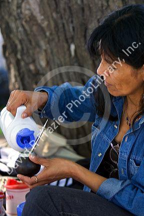 Argentine woman making mate in a calabash gourd in Buenos Aires, Argentina.