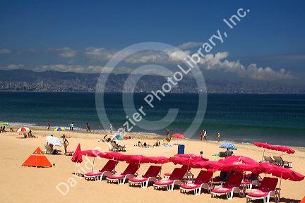 Beach scene in Renaca on the Pacific Ocean in Chile with Vina del Mar and Valparaiso in the background.