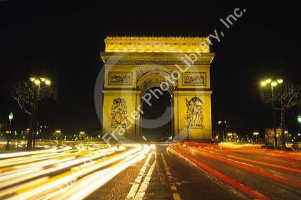 Night time traffic around the Arc De Triomphe in Paris, France.