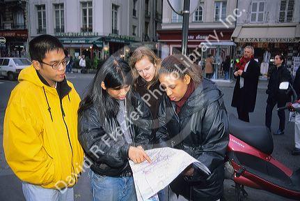 Multi racial college students looking at a map in Paris, France.