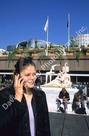 French woman using a cell phone in Paris, France.