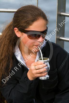 Girl drinking mate at Ushuaia on the island of Tierra del Fuego, Argentina.