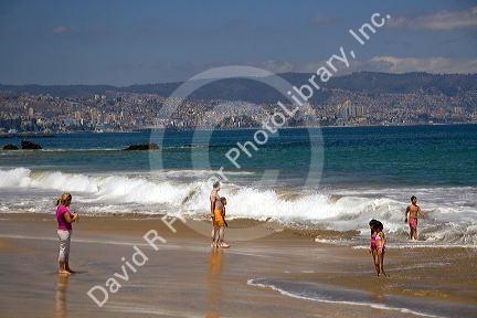 Beach scene in Renaca on the Pacific Ocean in Chile with Vina del Mar and Valparaiso in the background.
