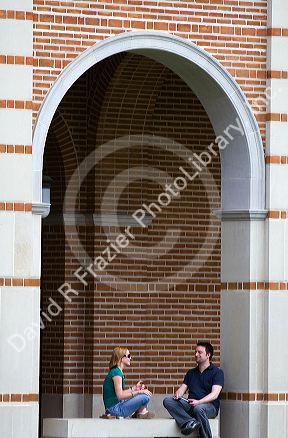 Students sit under an archway at Lovett Hall on the campus of William Marsh Rice University in Houston, Texas.