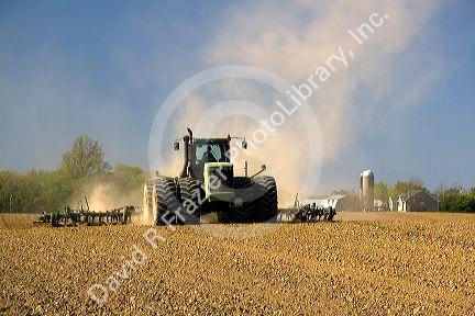 Tractor cultivating spring soil in Lapeer County, Michigan.
