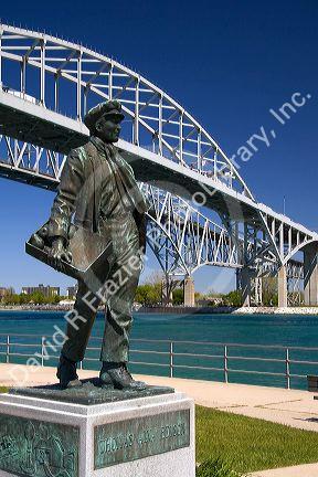 A statue of Thomas Edison by local artist Mino Duffy sits below the Blue Water Bridge along the St. Clair River at Port Huron, Michigan.