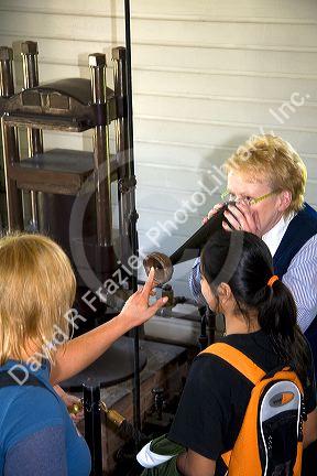 Tour guide showing children an Edison cylinder phonograph in the Thomas Edison Menlo Park laboratory in Greenfield Village at The Henry Ford in Dearborn, Michigan.