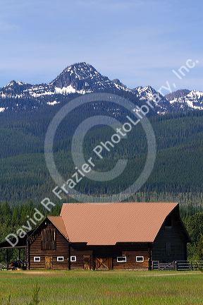 Log barn sits below the Mission Mountains north of Missoula, Montana.