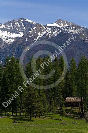 Log cabin sits below the Rocky Mountains near Condon, Montana.