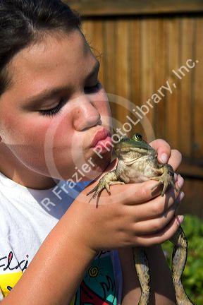 11 year old girl kissing a bullfrog in Boise, Idaho. MR