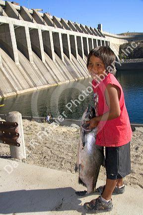 Colville Tribe NAtive American Indian boy holding a Chinook Salmon at Chief Joseph Dam in Washington.