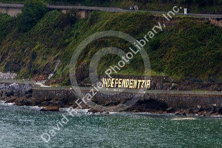 Independentzia painted on a rock wall by Basque separatists across the harbor from Ondarroa, Basque Country, Northern Spain.