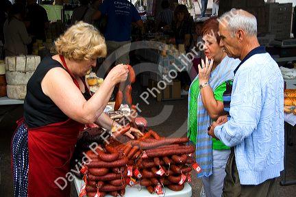 Vendor selling sausage at an outdoor market in the town on Cangas de Onis, Asturias, northern Spain.