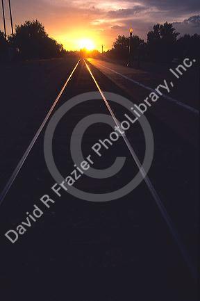 Railroad tracks converging lines at sunset.
