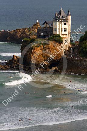 Surfing Cote de Basque below a castle in the Bay of Biscay at the town of Biarritz, Pyrenees Atlantiques, French Basque Country, Southwest France.