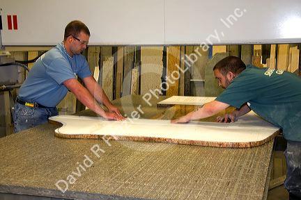Workers custom cutting a granite countertop at the Shaker Hill Granite Company located in the town of Enfield, New Hampshire, USA.