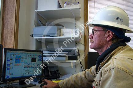 Operator using computers to monitor the system of a geothermal power plant in Malta, Idaho, USA. MR