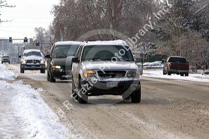 Automobiles driving in the winter snow in Boise, Idaho, USA.