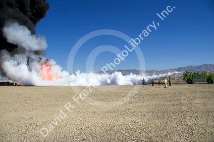Firefighters using fire retardant foam to put out a jet fuel fire at an airport training facility in Boise, Idaho, USA.