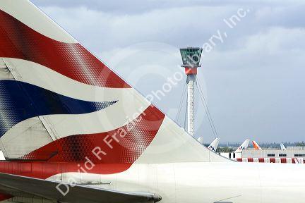 Airliner tail and control tower at London Heathrow Airport, England, United Kingdom.