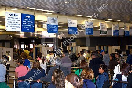 Pedestrians show identification and have their possesions searched to enter the United States port of entry at the Tijuana, Baja California, Mexico/San Diego, California border crossing.